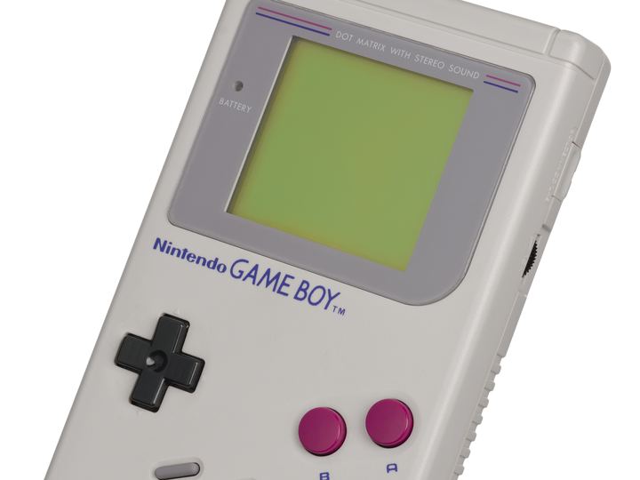 An original gray Nintendo Game Boy handheld with its green-tinted screen, black directional pad and two magenta buttons