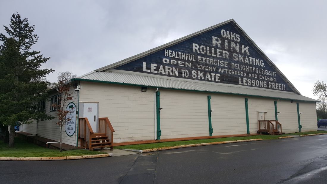 The long wooden building of the Oaks Park roller skating rink with a painted sign reading Learn to Skate