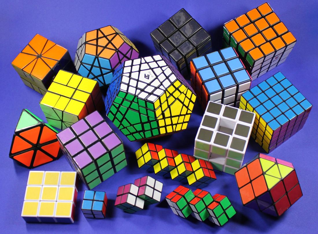A colorful collection of twisty puzzles on a blue background, including cubes of different sizes, a 12-sided puzzle and odd-shaped variations