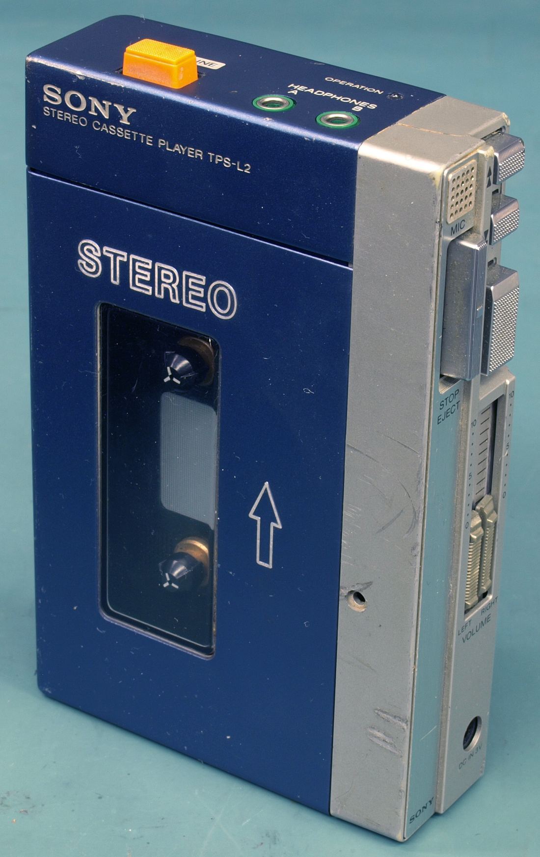 Close-up of an original 1979 Sony Walkman TPS-L2 standing upright, showing its cassette window and stereo label